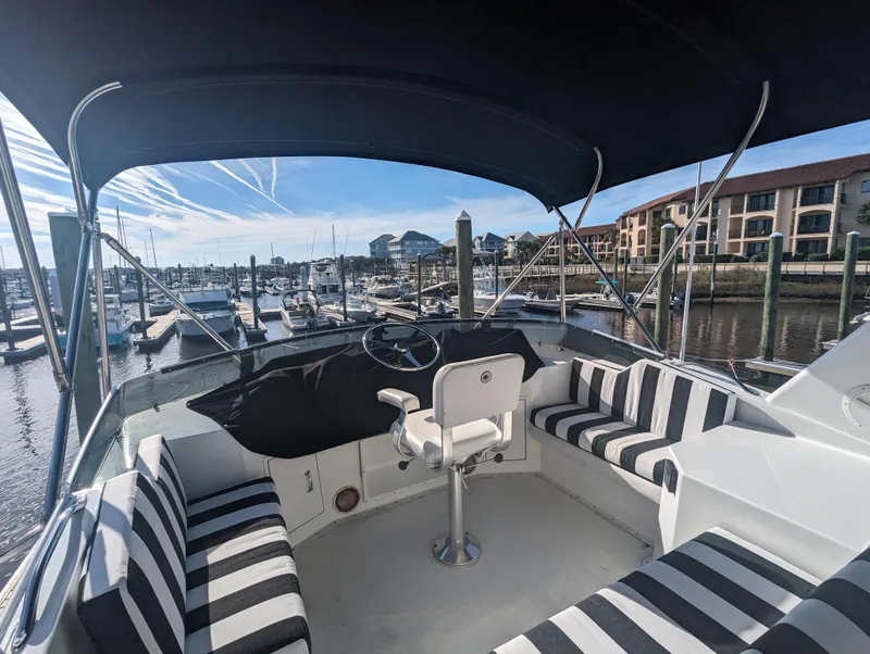 Slide: The Image of 1996 Hatteras 42 Cockpit MY yacht interior with striped seating at marina. - 3