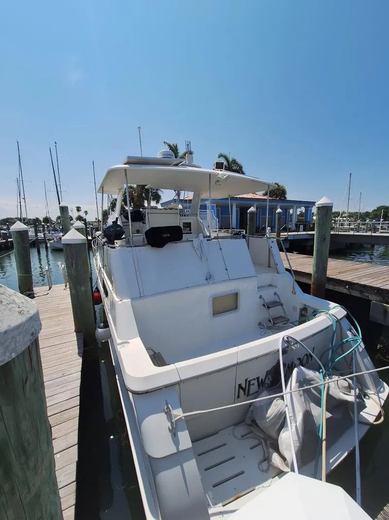 Slide: The Image of 1996 Hatteras 42 Cockpit MY docked at marina under clear blue sky. - 36