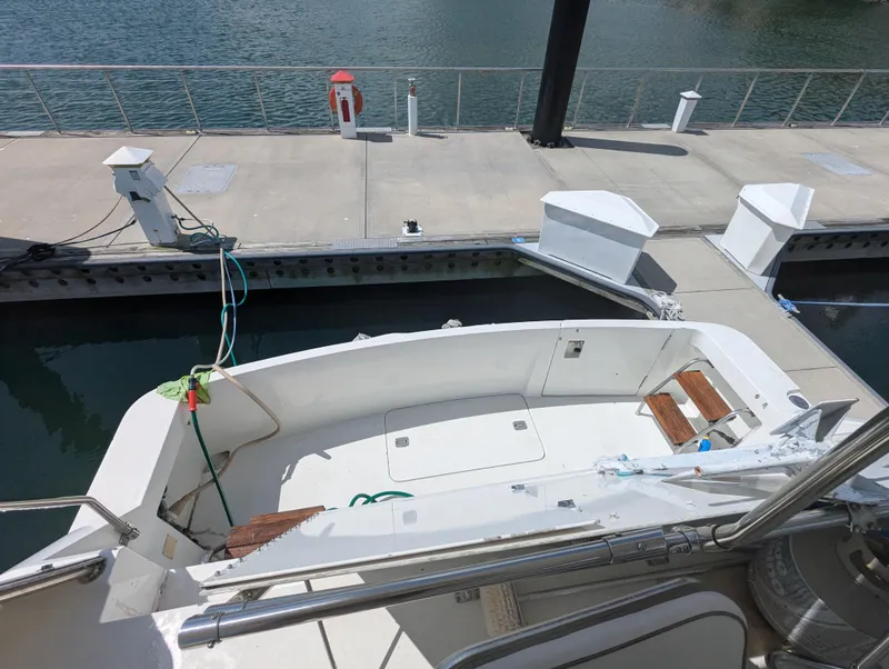 Slide: The Image of 1996 Hatteras 42 Cockpit MY docked at marina, showing spacious cockpit area. - 37