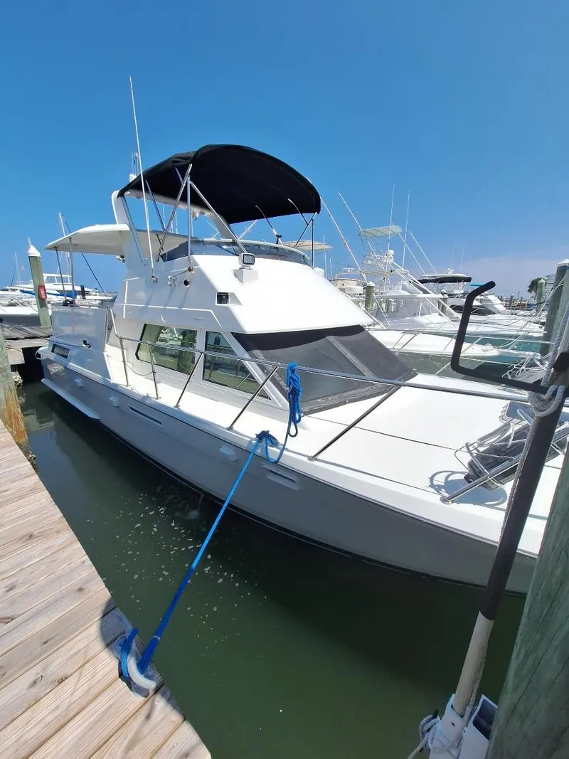 Slide: The Image of 1996 Hatteras 42 Cockpit MY yacht docked at marina under clear blue sky. - 42