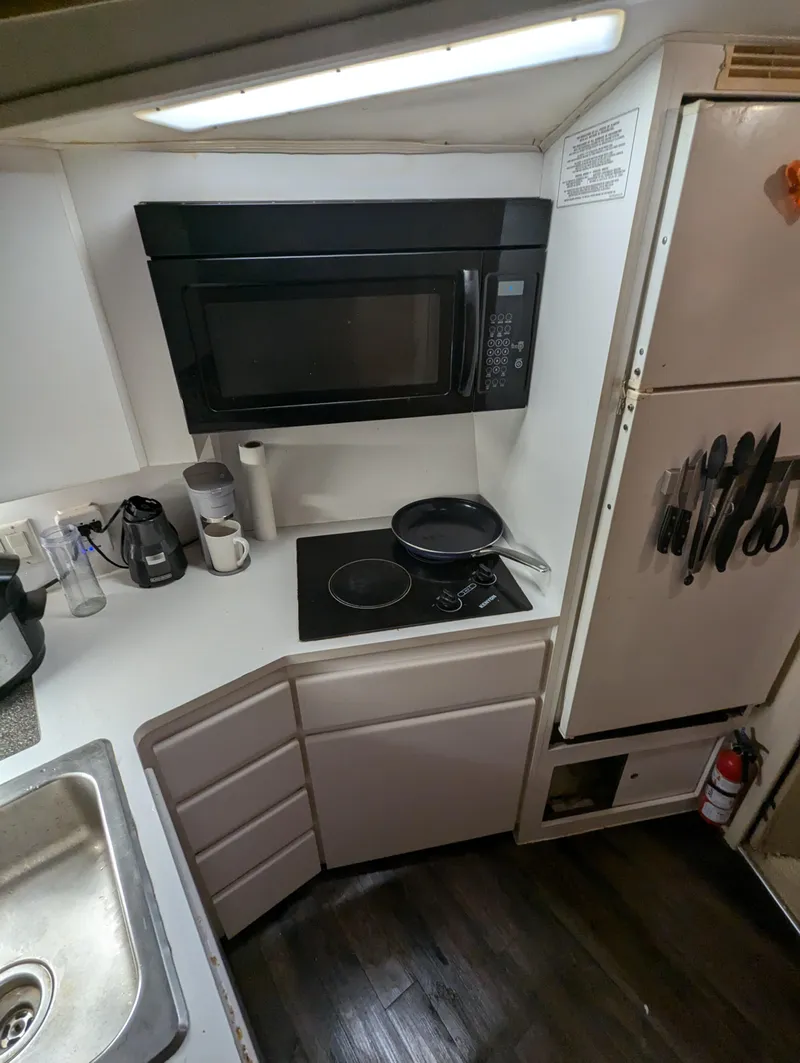 Slide: The Image of 1996 Hatteras 42 Cockpit MY kitchen with microwave, stove, and utensils. - 6