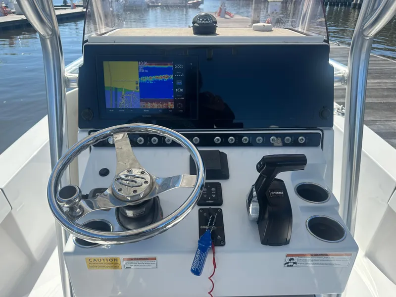 Slide: The Image of 2021 Sportsman Masters 247 Bay Boat dashboard with steering wheel and navigation display. - 13