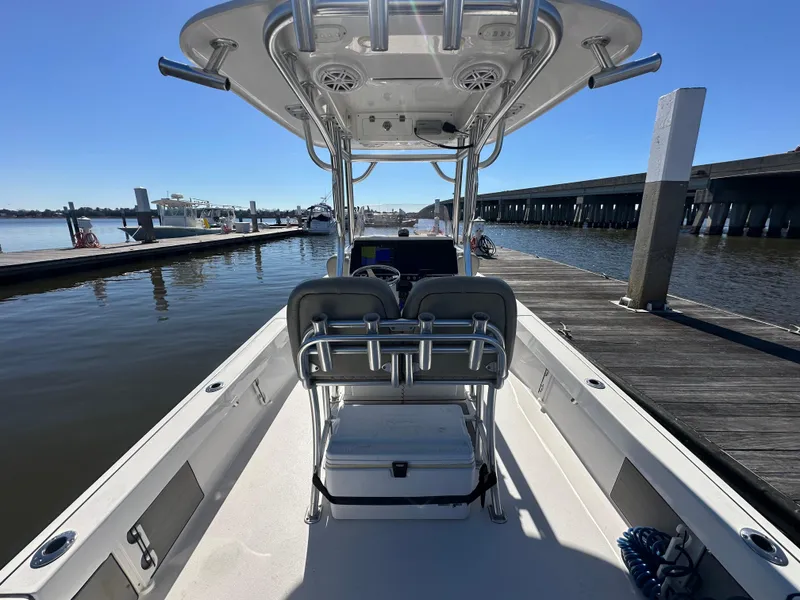 Slide: The Image of 2021 Sportsman Masters 247 Bay Boat docked at marina, showcasing spacious deck and seating. - 20