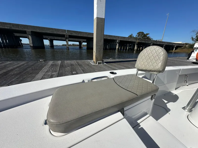 Slide: The Image of 2021 Sportsman Masters 247 Bay Boat with cushioned seating by a dock. - 27