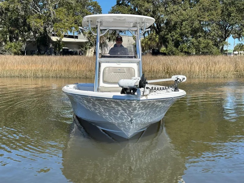 Slide: The Image of 2021 Sportsman Masters 247 Bay Boat on calm water, surrounded by trees. - 3