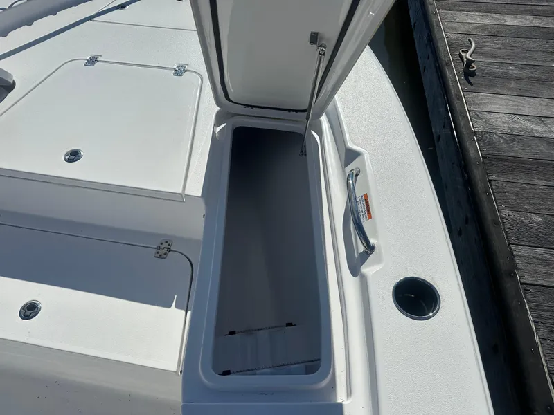 Slide: The Image of 2021 Sportsman Masters 247 Bay Boat open storage compartment on deck near dock. - 37