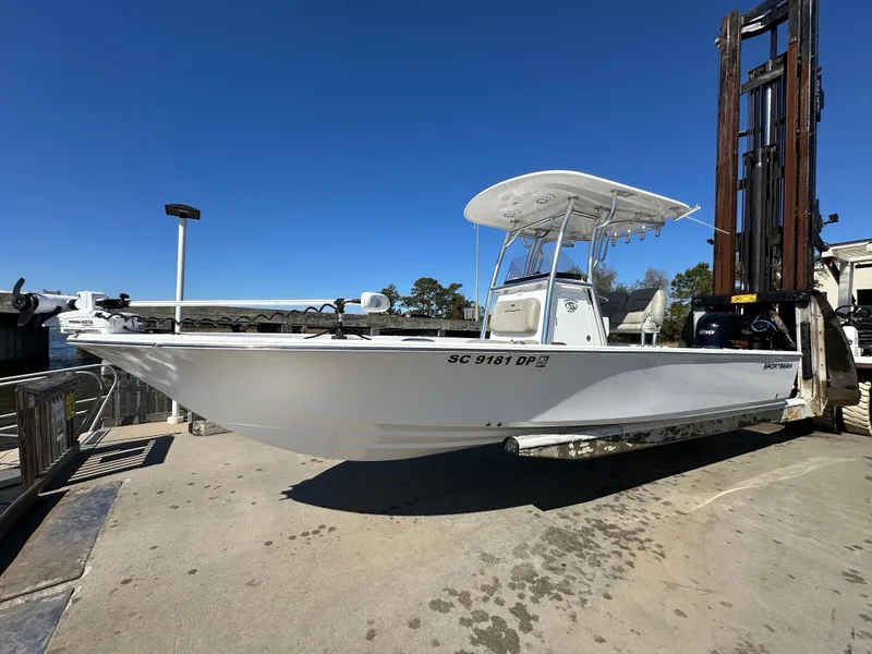 Slide: The Image of 2021 Sportsman Masters 247 Bay Boat on forklift, white hull, clear sky background. - 6