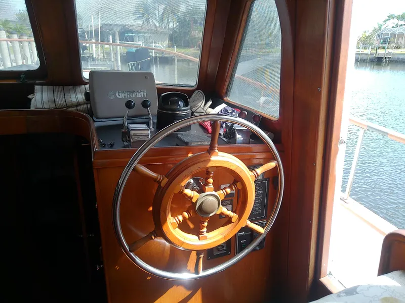 Slide: The Image of 1987 Albin 40 boat helm with wooden steering wheel and control panel. - 25