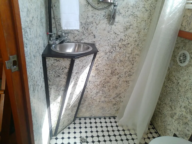 Slide: The Image of Compact bathroom in a 1987 Albin 40 boat with sink and shower curtain. - 34