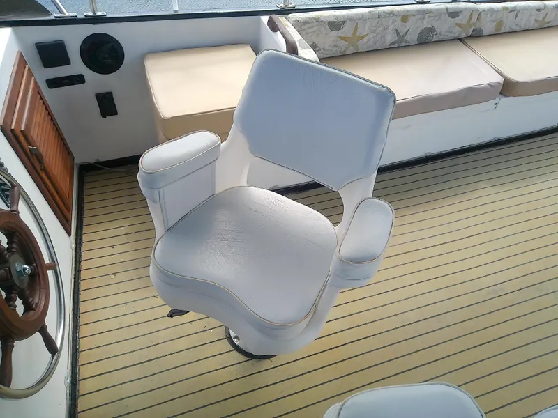 Slide: The Image of Captain's chair on 1987 Albin 40 boat with wooden deck and cushioned seating. - 40