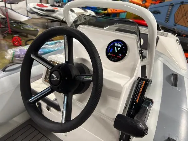 Slide: The Image of 2023 Highfield Sport 330 boat dashboard with steering wheel and digital display. - 9