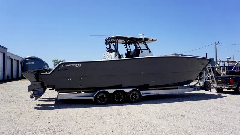 Slide: The Image of 2020 Freeman 37 VH boat on trailer with Yamaha engines, parked outdoors. - 14