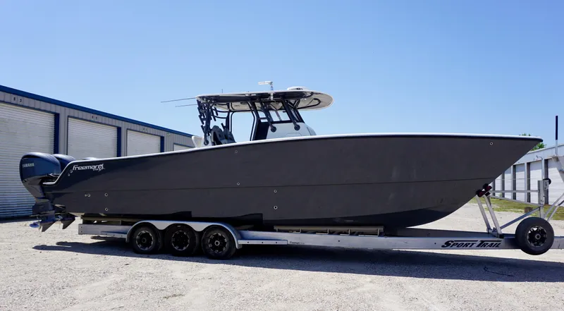 Slide: The Image of 2020 Freeman 37 VH boat on trailer, parked outdoors under clear sky. - 18