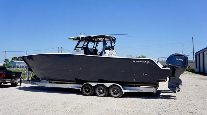 Slide: The Image of 2020 Freeman 37 VH boat on trailer with Yamaha engines, parked outdoors. - 5