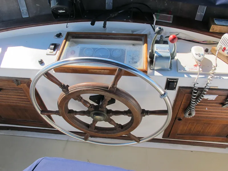 Slide: The Image of Wooden steering wheel and controls on a 1986 Monk 36 boat. - 11