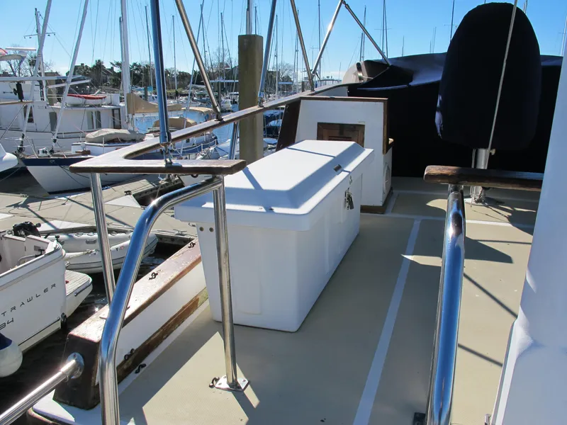 Slide: The Image of 1986 Monk 36 boat deck with storage box and railing in marina setting. - 15