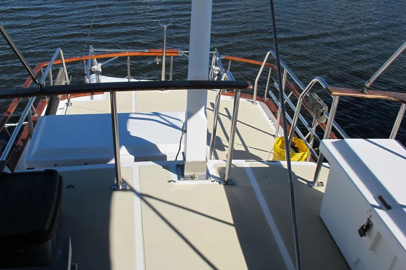 Slide: The Image of 1986 Monk 36 boat deck with railings and storage, overlooking calm water. - 17