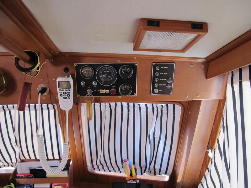 Slide: The Image of Control panel of a 1986 Monk 36 boat with striped curtains and communication equipment. - 19