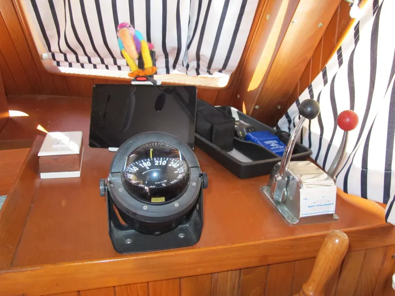 Slide: The Image of Boat interior with compass, throttle controls, and striped curtains on a 1986 Monk 36. - 20