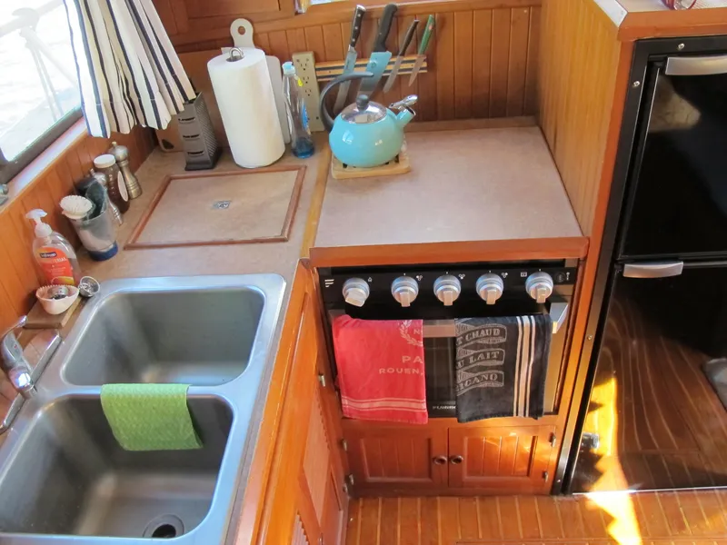 Slide: The Image of 1986 Monk 36 boat kitchen with sink, stove, and utensils. - 23