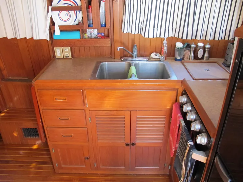 Slide: The Image of Wooden boat kitchen with sink, stove, and storage. Monk 36, 1986 model. - 24