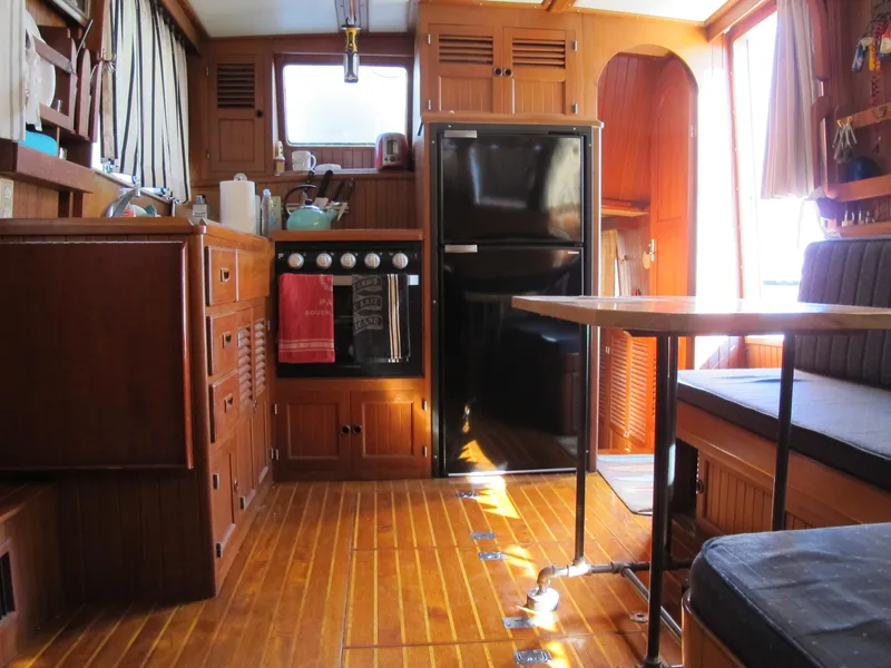 Slide: The Image of Interior of a 1986 Monk 36 boat with wooden cabinetry and dining area. - 26
