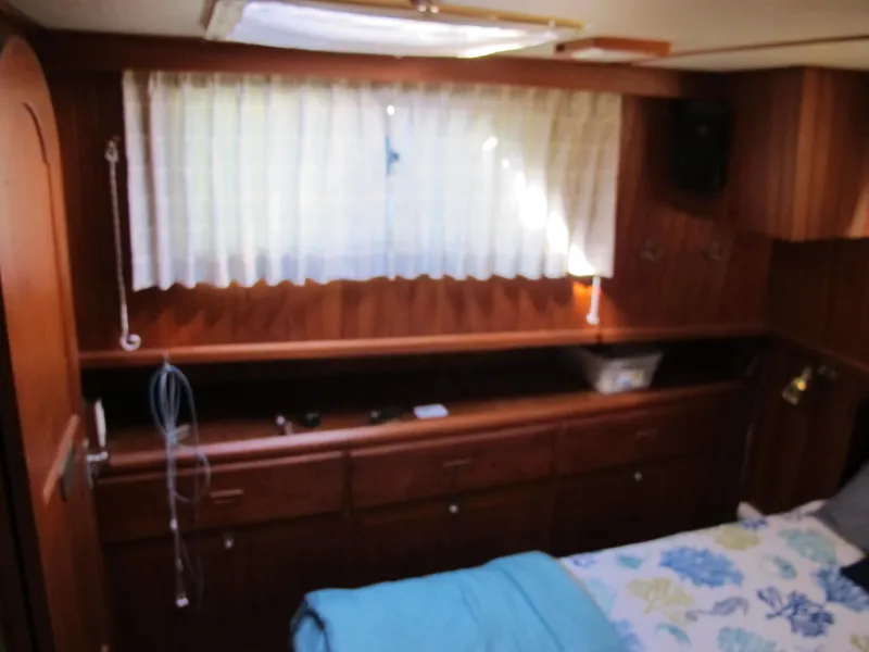 Slide: The Image of Cozy cabin interior of 1986 Monk 36 boat with wooden furnishings and a bed. - 31