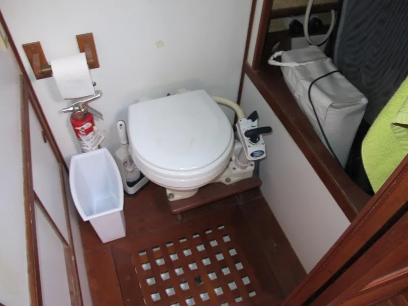 Slide: The Image of Compact boat bathroom with toilet, fire extinguisher, and waste bin on a Monk 36, 1986 model. - 35
