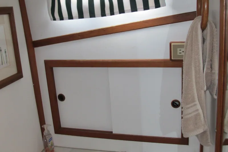 Slide: The Image of Interior of a 1986 Monk 36 boat with wooden trim and sliding cabinet doors. - 36