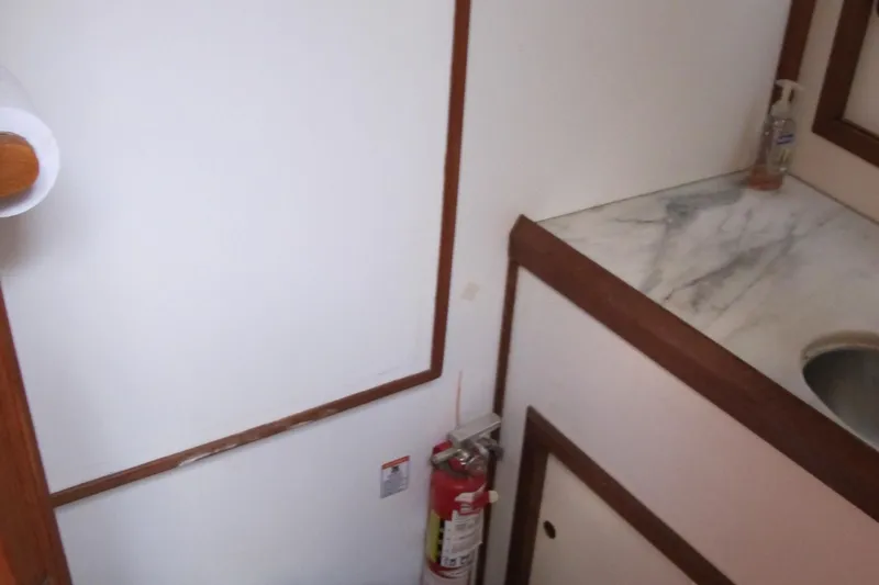 Slide: The Image of 1986 Monk 36 interior with sink, fire extinguisher, and marble countertop. - 37