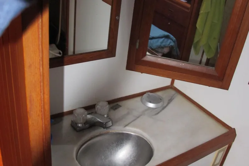 Slide: The Image of Compact bathroom sink area in a 1986 Monk 36 boat with wooden accents. - 39