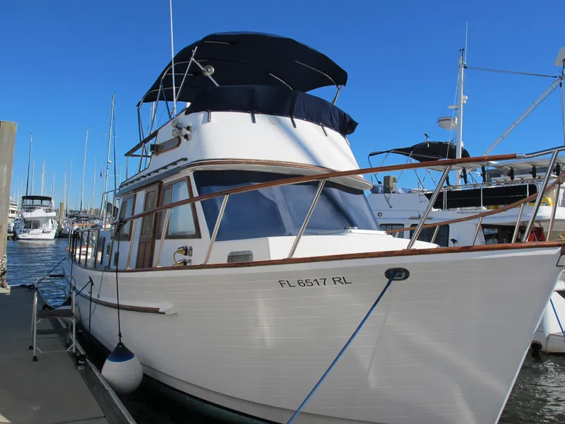 Slide: The Image of 1986 Monk 36 boat docked in marina, featuring classic design and white hull. - 4