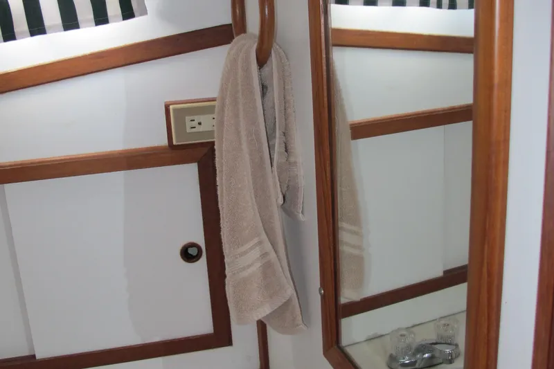 Slide: The Image of Interior of 1986 Monk 36 boat with towel, mirror, and wooden accents. - 40