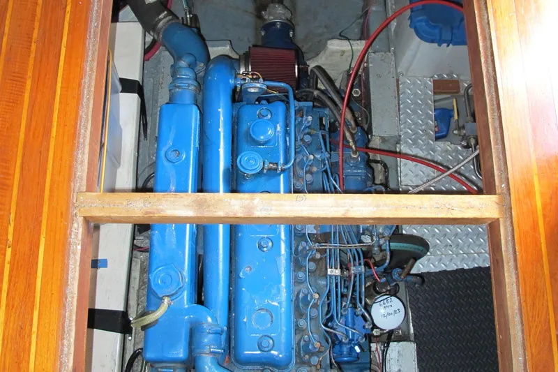 Slide: The Image of Engine compartment of a 1986 Monk 36, featuring a blue marine engine. - 45