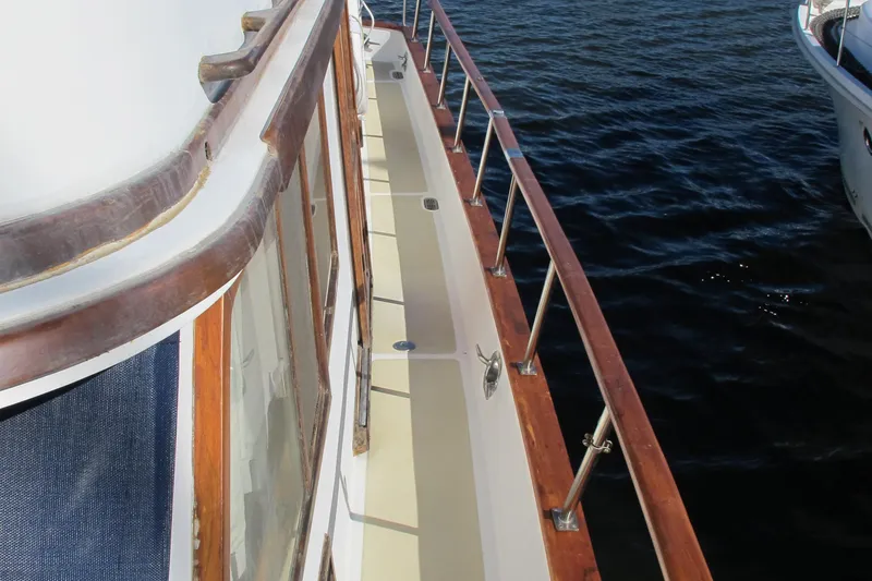 Slide: The Image of 1986 Monk 36 boat deck with wooden railings on calm water. - 7