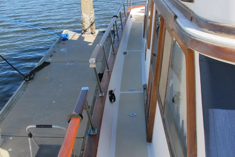 Slide: The Image of 1986 Monk 36 boat docked, showing deck and railing details. - 8