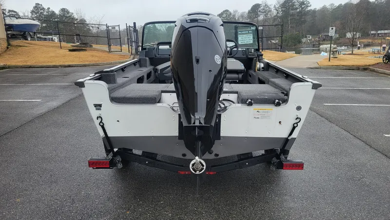 Slide: The Image of 2023 Lund 1775 Adventure Sport boat with outboard motor, parked on a wet pavement. - 3