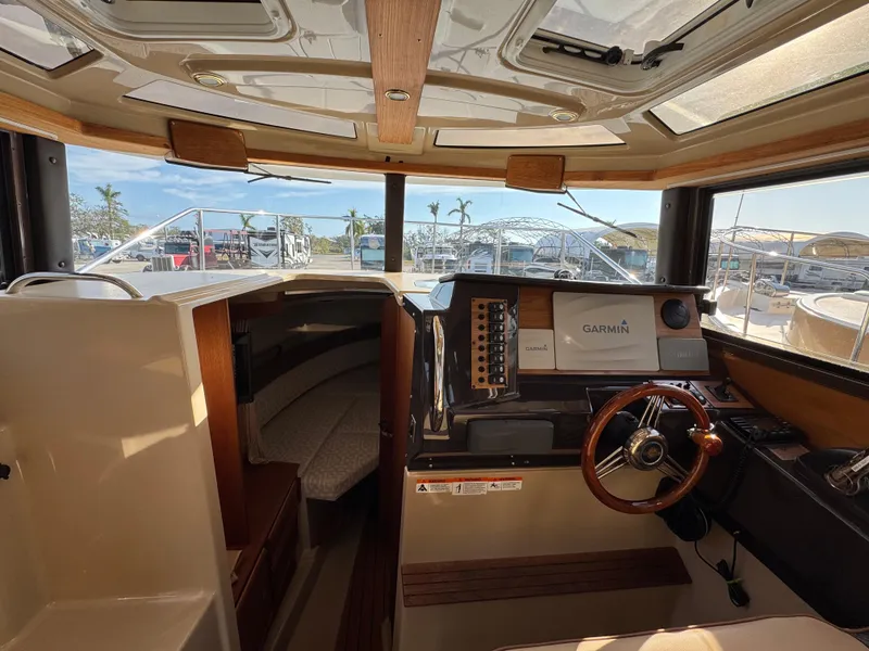 Slide: The Image of 2019 Ranger Tugs R-27 interior with helm, Garmin navigation, and cozy cabin space. - 6