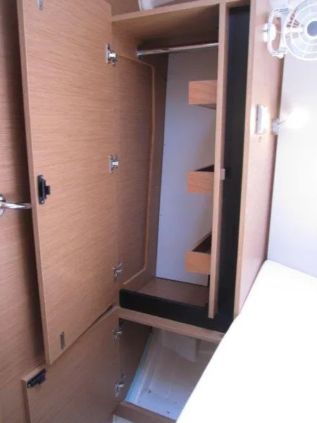 Slide: The Image of Interior storage of 2025 Jeanneau Sun Odyssey 350 sailboat, featuring wooden cabinetry and shelving. - 26