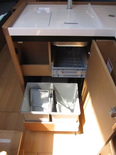 Slide: The Image of 2025 Jeanneau Sun Odyssey 350 yacht kitchen with modern cabinetry and storage bins. - 40