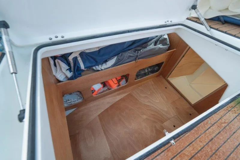 Slide: The Image of Storage compartment in 2025 Jeanneau Sun Odyssey 350 sailboat, featuring organized space and wooden finish. - 48