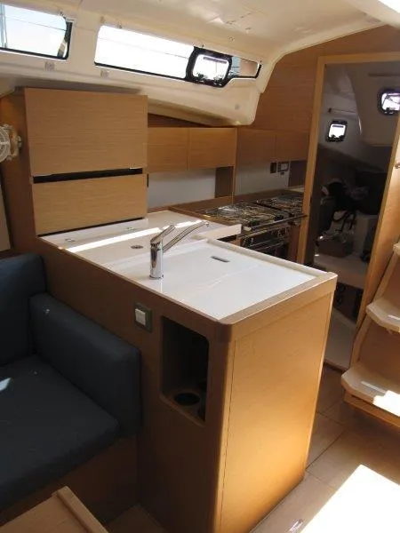 Slide: The Image of Interior of 2025 Jeanneau Sun Odyssey 350 yacht, featuring modern kitchen and seating area. - 10