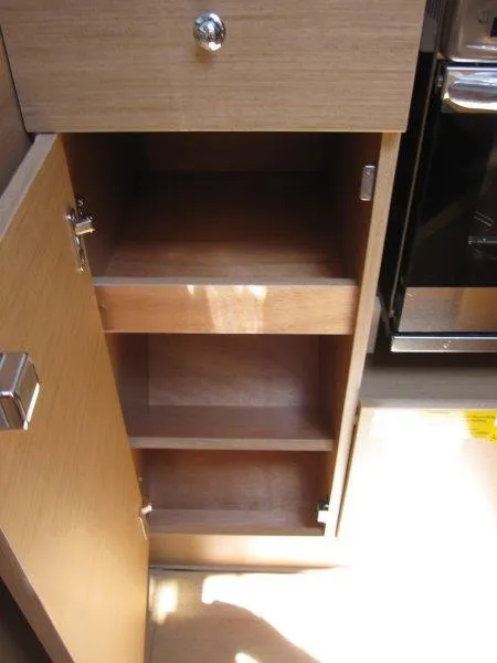 Slide: The Image of 2025 Jeanneau Sun Odyssey 350 interior cabinet with open shelves and wooden finish. - 42