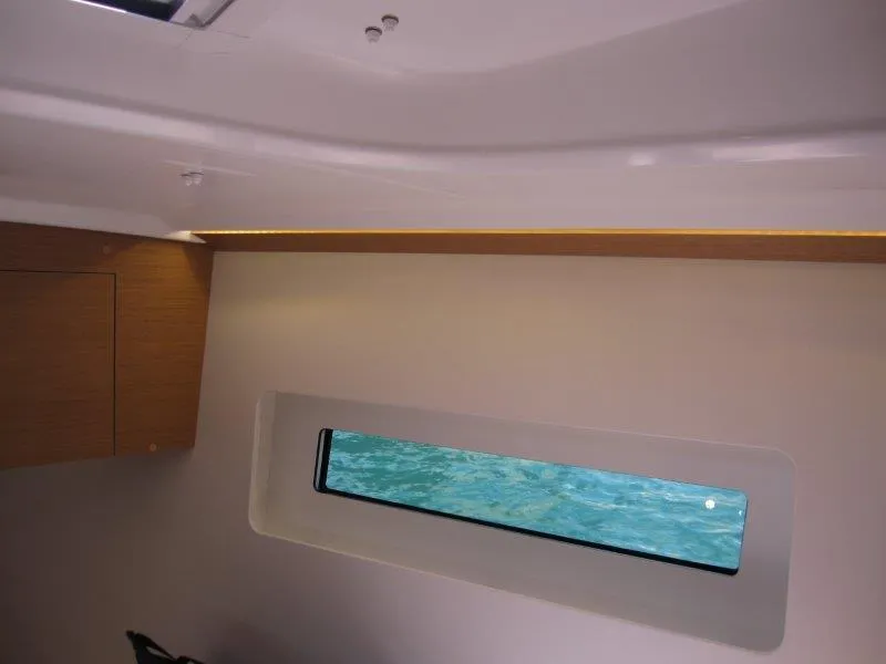 Slide: The Image of Interior view of 2025 Jeanneau Sun Odyssey 350 yacht with window and wooden accents. - 34