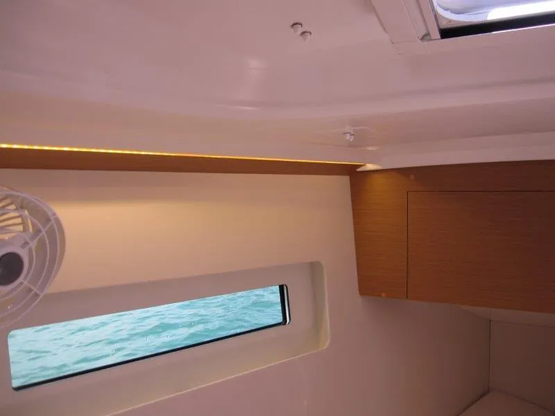 Slide: The Image of Interior view of 2025 Jeanneau Sun Odyssey 350 yacht cabin with window and fan. - 33