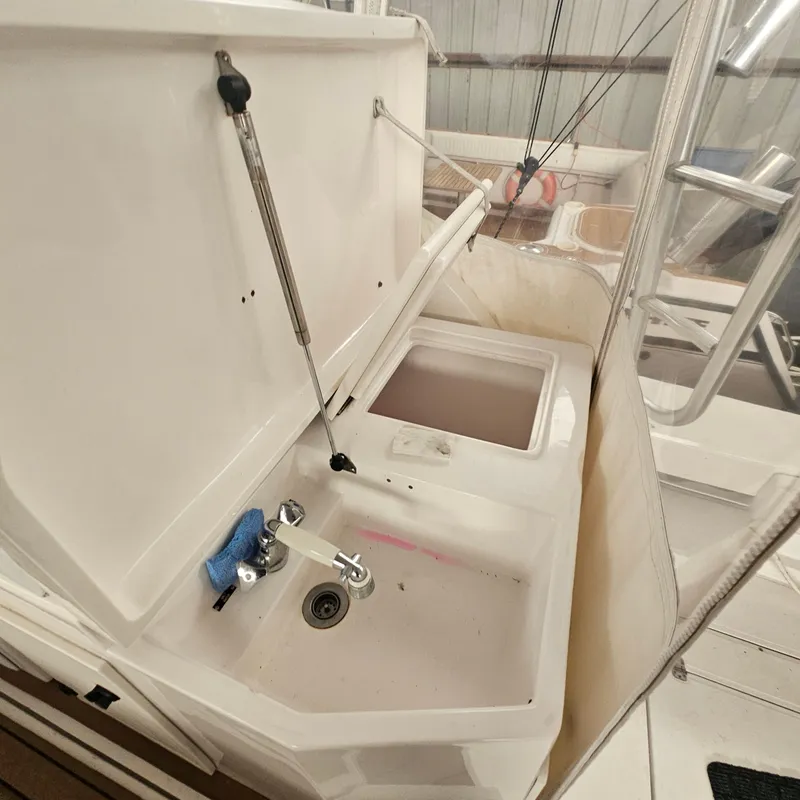 Slide: The Image of 1994 Blackfin 33 Combi boat sink and storage area, featuring a clean, white design. - 16