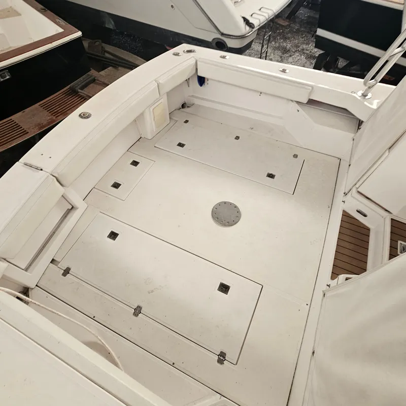 Slide: The Image of 1994 Blackfin 33 Combi boat deck, featuring spacious white interior and storage compartments. - 18