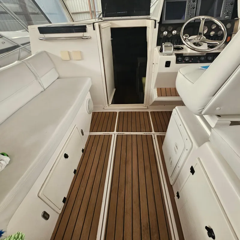Slide: The Image of Interior of a 1994 Blackfin 33 Combi boat with wooden flooring and white seating. - 24