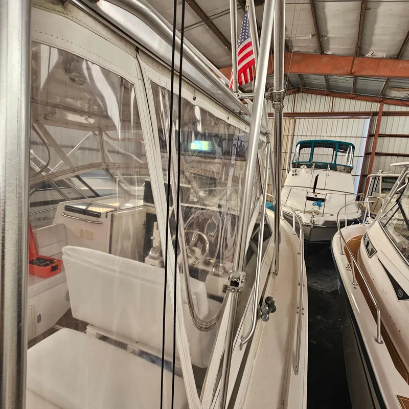 Slide: The Image of 1994 Blackfin 33 Combi boat in storage, featuring American flag and interior view. - 6