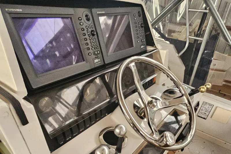 Slide: The Image of 1994 Blackfin 33 Combi boat dashboard with dual navigation screens and steering wheel. - 9
